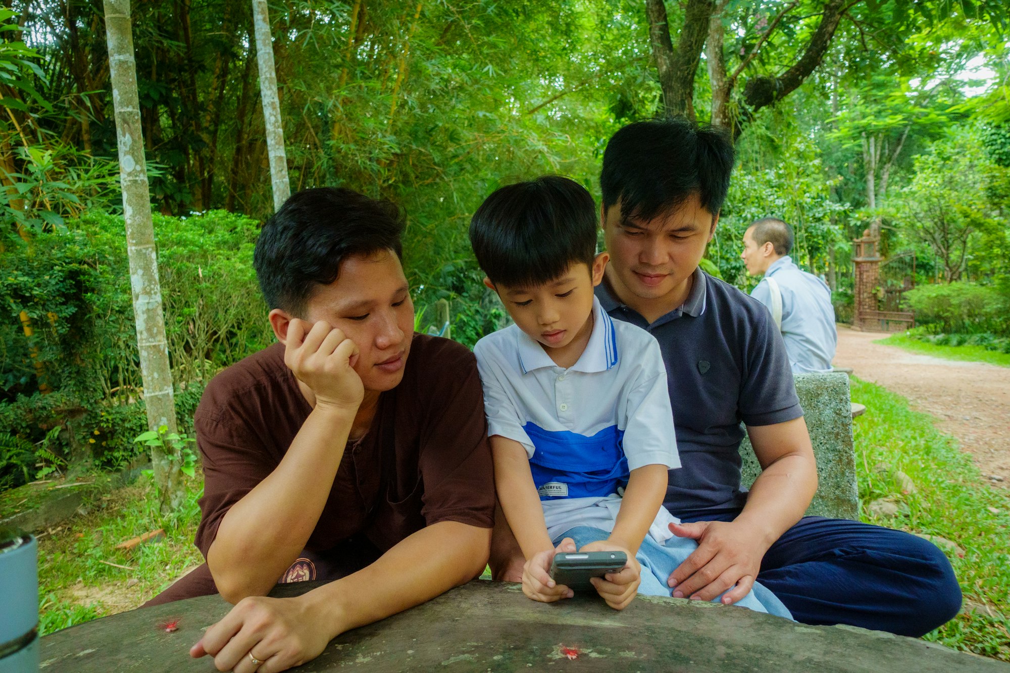 A parent and child looking at a phone together outdoors
